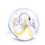 A glass ball with purple and yellow swirls.